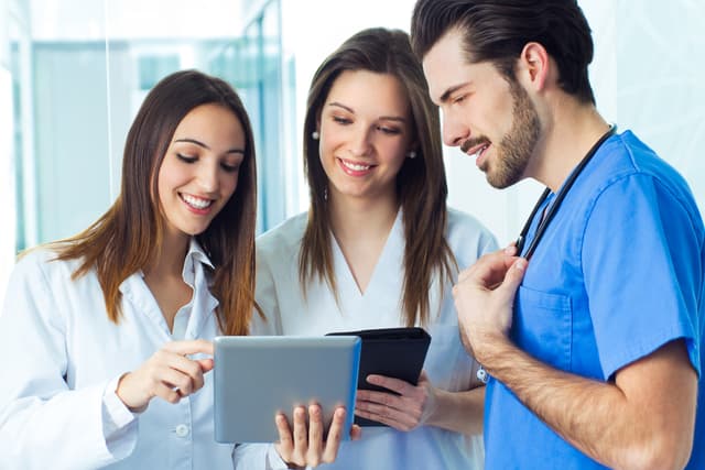 Group of healthcare workers smiling at phone screen